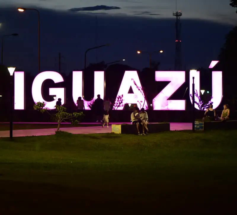 Letras iluminadas de Iguazú en una plaza al anochecer